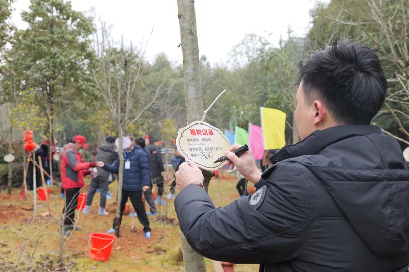 图注3：来自广东省河源市的市民代表在植树记录牌上签字署名。_副本.jpg